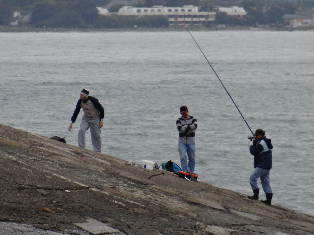 3 men, one fishing rod - either that is one big fish or it is a fishing union - one worker, a manager and a supervisor