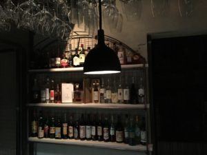 Bar lighting bottles in basement bar at Over London