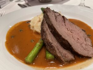 Cruise meal of prime rib beef, mashed potatos and asparagus spears in a brown gravy