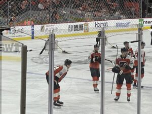 View from Sec 122 of Philadelphia Flyers hockey players during commercial break with ice sweepers in background