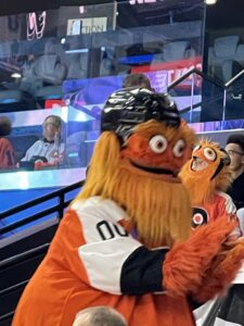 Gritty Philadelphia Flyers Mascot - a life sized orange muppet like furry googly eyed monster wearing hocket helmet and jersey