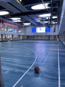 Large multifunctional activity space set up for basketball and used for pickleball, bumper cars and ice skating