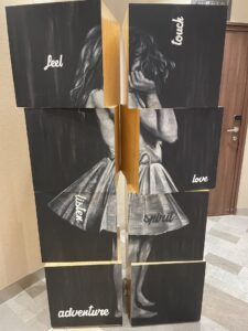 artwork of blocks that show a young girl in ballerina skirt black and white and positive words on each block that appears to move and rotate. approx six feet high