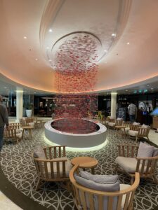 Centerpiece artwork from the ceiling looks like orange rain with seating around the artwork i