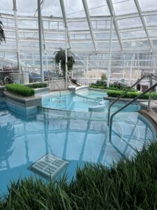 Clear water multi level pools and green landscaping in the solarium on Royal Caribbean
