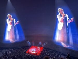 View of U2 stage in red at the sphere with projections of Bono on the walls on either side of the stage