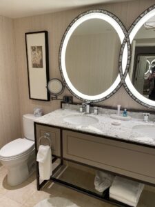 Bellagio bathroom vanity two circular lighted mirrors with double sinks and picture over toilet