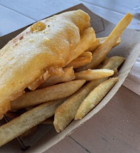 Fried fish and chips (fries) in a paper basket at Epcot