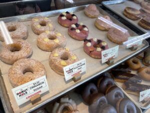 Carl's Hole in the Wall donut shop in Las Vegas showing four donuts up and across in various flavors and colors