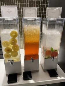 Three clear rectangular beverage containers with infused water and ice options at Polaris lounge