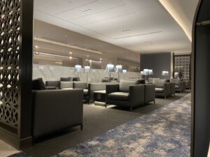 brown lounge seats with blue and grey rugs and white light lamps at United Polaris lounge Newark