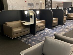 Lounge seating with side table and lamp light to work at United Polaris lounge at Newark