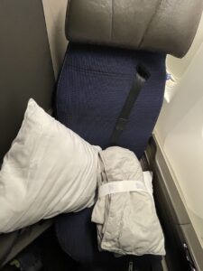 United Polaris Business Class Seat - navy blue with white pillow and blanket